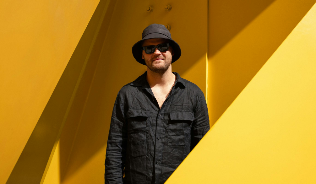 ALT Text: Two men looking at date and having the binary code floating Infront of them and out of the computer